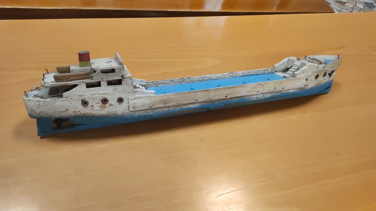 Modellino di nave cargo in legno colorato. Oggetto a uso ludico, datato tra gli anni Cinquanta e Sessanta del Novecento e conservato presso il Museo dell'Educazione del Dipartimento di Filosofia, Sociologia, Pedagogia e Psicologia Applicata dell'Università di Padova.